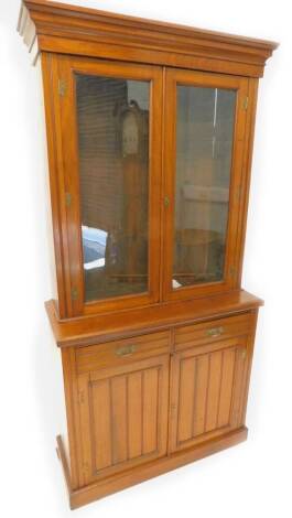 A Victorian walnut bookcase, the top with a moulded cornice, with two glazed doors, the base with two frieze drawers and two panelled doors on a plinth, 104cm W.