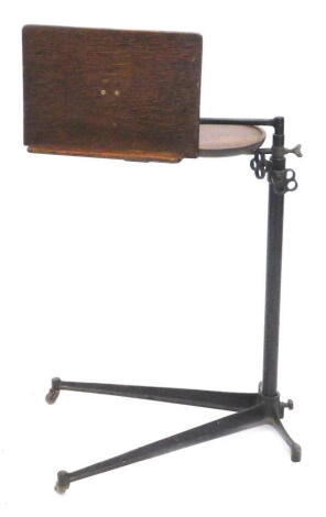 An Edwardian ebonised metal and oak adjustable music stand, on played base.