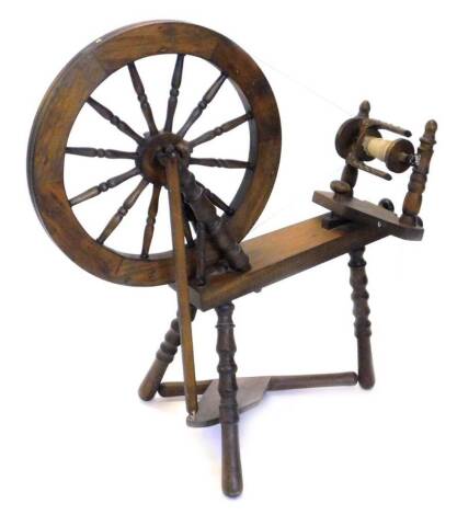 A modern pine and beech spinning wheel, on turned legs, accessories included with lot.