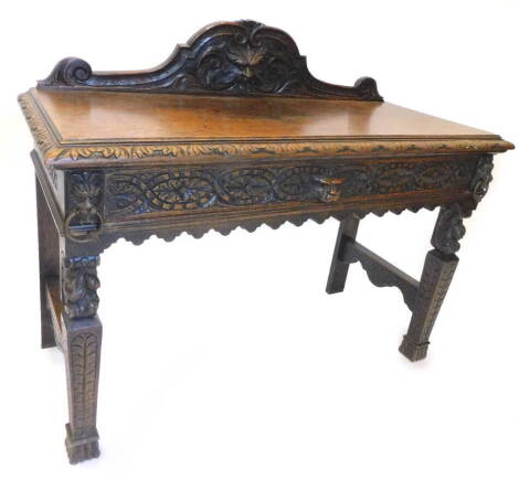 A Victorian carved oak side table, with a raised back above a single frieze drawer decorated with lion mask handle on tapering legs, 120cm W.