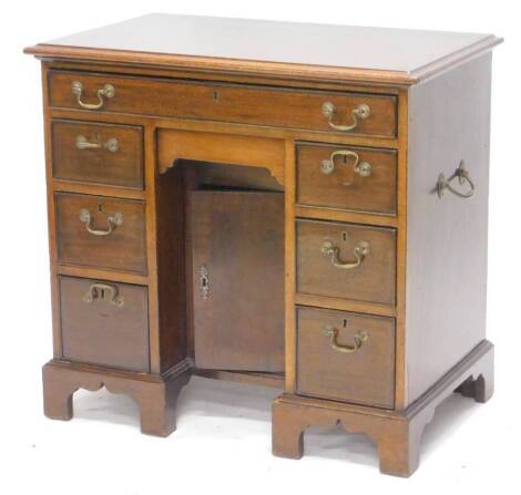 A 19thC and later mahogany kneehole desk, the rectangular top with a moulded edge above an arrangement of one long and six short drawers around a kneehole with concealed drawer and a door, on bracket feet with side handles, 82cm W.