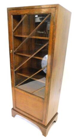 An oak bookcase, with a single glazed and part panelled door on bracket feet, 56cm W.