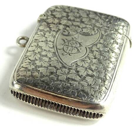 A late Victorian silver Vesta case, engraved with a tight design of leaves, around a shield shaped cartouche, engraved with a monogram, Birmingham 1892 by Colin Hewer Cheshire, 38g.