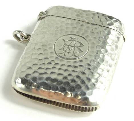 An Edwardian silver Vesta case, with hammered decoration around a circular cartouche with monogram, Birmingham 1903, by W. G Keight, 32.2g.