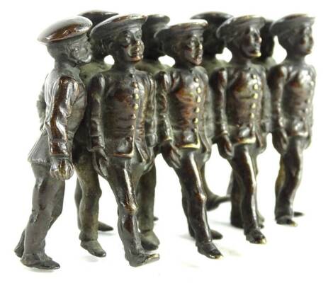 A cold painted bronze group of nine marching soldiers, in the manner of Bergman, 9cm W.