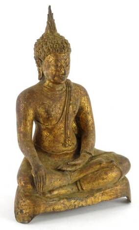 A gilt metal Indian figure of a seated god, with eyes closed and legs crossed, on shaped base, 22cm H.