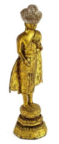 A gilt metal figure of an Indian god, in standing pose, on a stepped base, picked out with flowers, 6cm H.