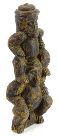 A heavily carved wooden tribal style figure group, partially ebonised set with a figure on the shoulders of another, on a removable base, 26cm H.