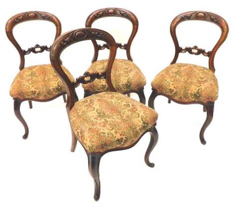 A set of four Victorian mahogany balloon back chairs, each with a padded seat on cabriole legs.