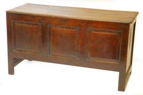 A late 17thC/early 18thC oak coffer, the planked top with a moulded edge, above a panelled front, on stiles, 125cm W.