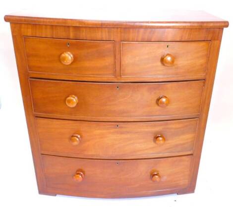 A Victorian mahogany bow front chest of drawers, the top with a moulded edge above two short and three long drawers each with turned wood handles, lacking feet, 102cm W.