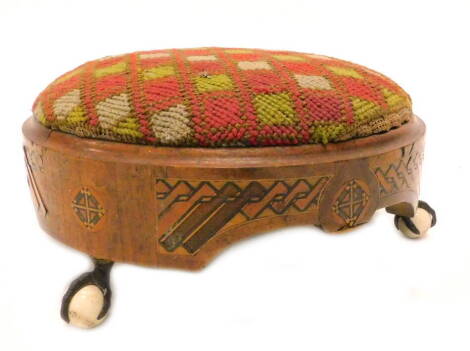 A Victorian walnut and parquetry footstool, with a wool work seat on gilt metal ceramic ball and claw feet, 31cm dia.