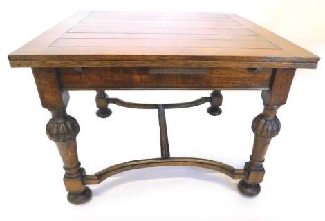 An early to mid 20thC oak draw leaf dining table, the rectangular top on bulbous part turned supports with H stretcher and bun feet, the top 180cm x 106cm.