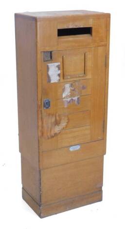 An unusual teak letter box, with brass fittings, applied with a plaque stating, This cabinet is the property of the manufacturers, National Automatic Machines Limited, 99 Cobbold Road, London, 112cm H, 44cm W.