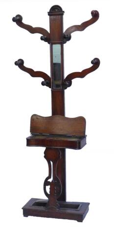 A Victorian mahogany hall stand, with three shaped arms, each containing two hooks, on a central support with mirror, above a hinged flap, containing various brushes, with pierced splat like support and metal drip tray, 186cm H.