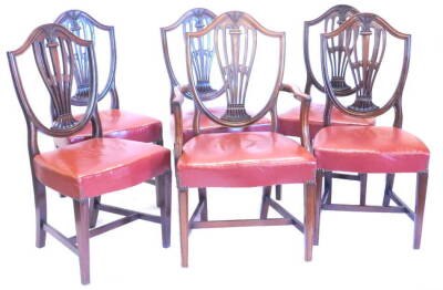 A set of six 19thC mahogany dining chairs in George III style, each with a shield shaped back with pierced splat carved with wheat ears a padded red leather seat on square tapering legs with H stretchers, one with arms.