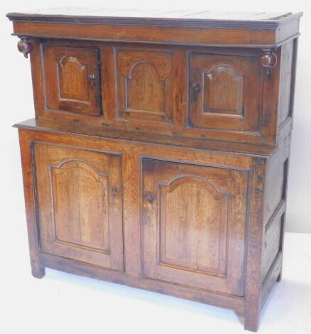 A 17thC oak deudarn, the raised back with three carved panel doors and drop finial's, the base with two panel doors on stiles, 141cm H, 132cm W.