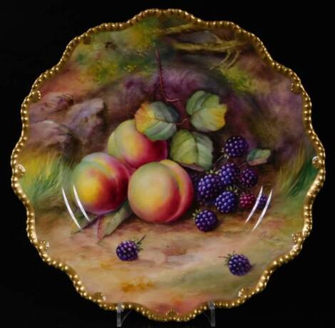 A 20thC Royal Worcester Thomas Lockyer porcelain plate, handpainted with fruits, brambles and peaches, with a flared gilt lined border, printed marks beneath, 23cm W.