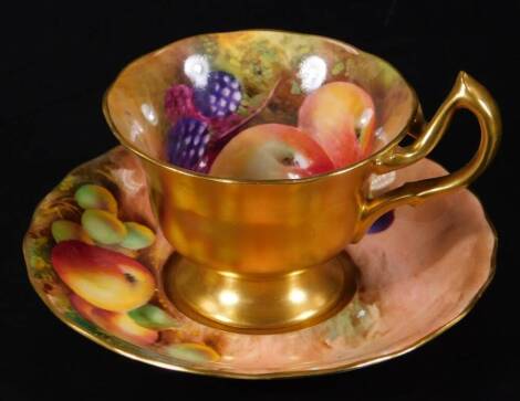 A Royal Worcester tea cup and saucer, painted with fruit and signed Moseley, blue puce marked, c1928, 12cm Dia.