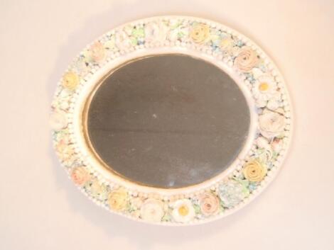 A 19thC German porcelain wall mirror with an oval floral frame