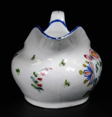 A Newhall clip handle creamer, c1780, 10cm H, together with a low creamer decorated with a flower group below a blue rim, pattern no 940, 14cm W. (2) - 3