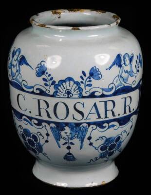 An early 18thC English Delft apothecary jar, inscribed C Rosar R within a cherub and flower swag cartouche, 18cm H.