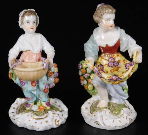 A pair of mid 19thC continental porcelain salt seller figures, of girls holding apron or basket, marked A/R, 12cm H.