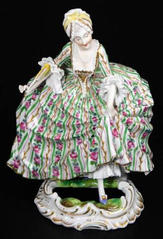 A continental porcelain figure of a lady, in crinoline dress, florally decorated predominately in pink, green with gilt highlights, on a pierced base, with Sevres double Louis S marks beneath, 21cm H.