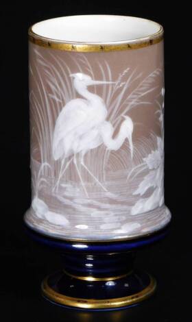 A late 19thC pate sur pate vase, in the manner of George Jones, the bellied circular body decorated with storks amongst reeds, on a circular gilt lined foot, unmarked, 14cm H.