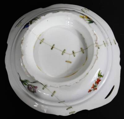 A 19thC continental porcelain part dinner service, each piece profusely decorated with handpainted flowers predominately in blue, green and orange, to include two lidded tureens, 30cm W, a pair of sauce dishes and covers, serving dishes, plates, etc. each - 12