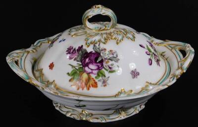 A 19thC continental porcelain part dinner service, each piece profusely decorated with handpainted flowers predominately in blue, green and orange, to include two lidded tureens, 30cm W, a pair of sauce dishes and covers, serving dishes, plates, etc. each - 13