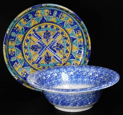 A 19thC blue and white sponge ware bowl, of circular form, 33cm Dia. and continental tin glazed charger, heavily decorated with a repeat geometric pattern predominately in blue, yellow and turquoise, on a circular foot. (2)