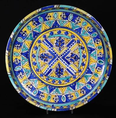 A 19thC blue and white sponge ware bowl, of circular form, 33cm Dia. and continental tin glazed charger, heavily decorated with a repeat geometric pattern predominately in blue, yellow and turquoise, on a circular foot. (2) - 2