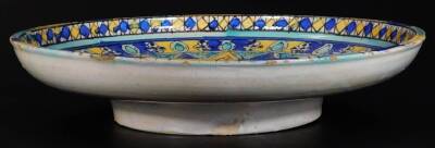 A 19thC blue and white sponge ware bowl, of circular form, 33cm Dia. and continental tin glazed charger, heavily decorated with a repeat geometric pattern predominately in blue, yellow and turquoise, on a circular foot. (2) - 3