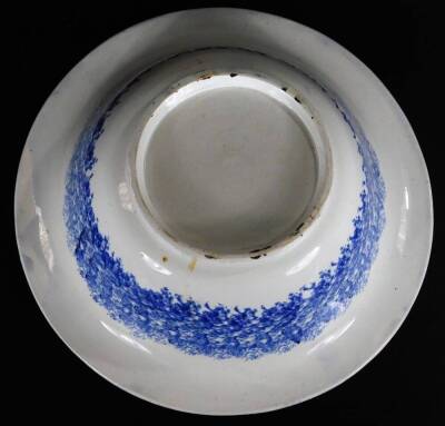 A 19thC blue and white sponge ware bowl, of circular form, 33cm Dia. and continental tin glazed charger, heavily decorated with a repeat geometric pattern predominately in blue, yellow and turquoise, on a circular foot. (2) - 7