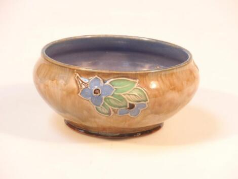 A Royal Doulton stoneware bowl decorated with flowers and foliage in relief