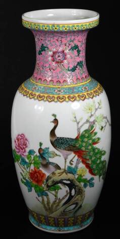 A Chinese Republic porcelain vase, the compressed trumpet stem decorated with flowers on a pink ground, the shouldered body with a heart and geometric border, raised above various exotic birds in a naturalistic setting, on circular foot, red seal mark ben