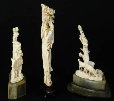 A late Meiji period ivory figure, of a standing Geisha in flowing robes holding floral staff, on a wooden base, 16cm H and two further ivory carvings. (3) - 4