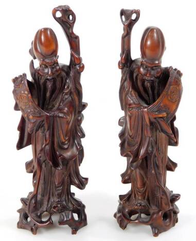 A pair of heavily carved Chinese root carved figures, of sages each holding a staff, on naturalistic bases, 18cm H. (2)