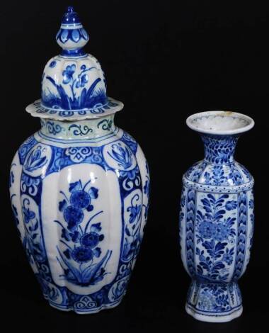 A continental tin glazed earthenware blue and white jar and cover, of shaped form, with domed lid, the ribbed body decorated with panels of flowers broken by a geometric pattern of further flowers, 45cm H, and a Delft vase of shouldered form. (2)