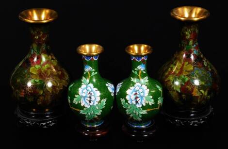 A pair of cloisonne vases, of bulbous form with trumpet stems, decorated with flowers in green and brown, on removable wooden bases, 16cm H, and a further pair of smaller cloisonne vases. (4)