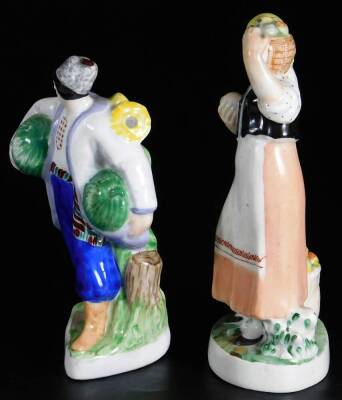 Two Russian porcelain figure groups of farmers or fruit sellers, the male figure holding melon under his arms, painted in blue, red and green, red Lomonosov porcelain mark, the other a female figure holding a basket of apples on her shoulder and another a - 2