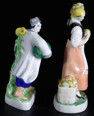 Two Russian porcelain figure groups of farmers or fruit sellers, the male figure holding melon under his arms, painted in blue, red and green, red Lomonosov porcelain mark, the other a female figure holding a basket of apples on her shoulder and another a - 4