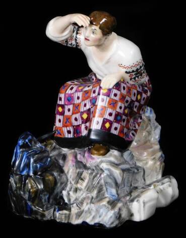 A rare and important Russian porcelain Natalina Danko figure of a female worker, wearing an elaborate dress with a pick and spade at her feet, possibly used as an inkwell, c,1920, signed, 12cm H. (AF)