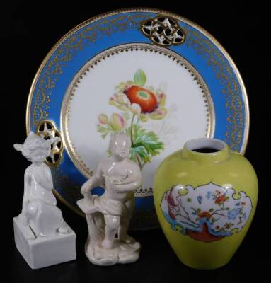 A 18thC continental figure of putti as a artist, a white figure of an oriental figure holding a fan on a rectangular base, a yellow ground continental ginger jar in the oriental style, together with a 19thC reticulated cabinet plate decorated with a cornf