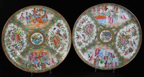 A pair of 19thC Cantonese famille rose plates, each decorated with panels of figures in interior scenes and centred by a section of flowers, predominately in pink, green and orange, 25cm Dia. with R N Myers receipt.