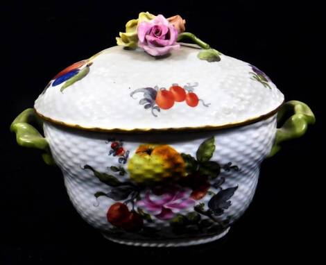 A 20thC Herend of Hungary porcelain two handled dish, the domed lid with a lattice work moulding, set with various flowerheads and fruits, with a floral knop, the main body similarly decorated, flanked by shaped handles, predominately in pink, yellow and 