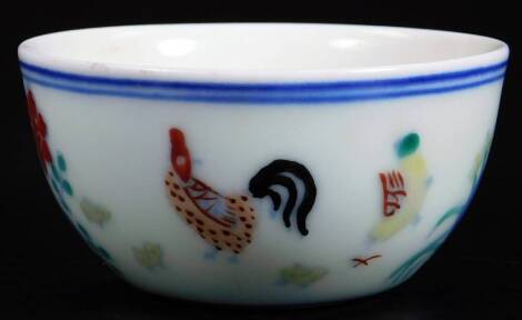 A Chinese porcelain tea bowl, the circular body decorated with cockerel and flowers, predominately in red, green and blue, double line Chenghua mark, but later, 8cm Dia.