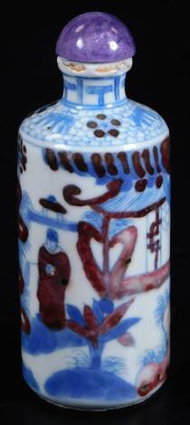 A Chinese porcelain snuff bottle, decorated in blue and white with figures in a garden, over painted in iron red, bears Yongzheng six character mark, 10cm H.