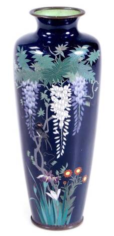 An early 20thC cloisonné vase, of shouldered form, decorated with butterflies and flowers on a blue ground, with a light green interior, on circular foot, unmarked, 20cm H.